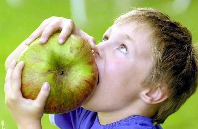 мальчик ест яблоко